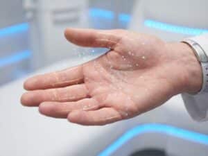 Menselijke hand met visualisatie van tintelingen door lichtdeeltjes en gouden zenuwbanen onder de huid