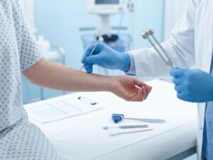 Dokter in blauwe handschoenen voert neurologisch onderzoek uit op patiëntarm met medische instrumenten op witte tafel