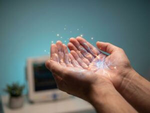 Handen met gloeiende zenuwbanen en gouden tintelingen die stress en fysieke sensaties visualiseren tegen blauwe achtergrond