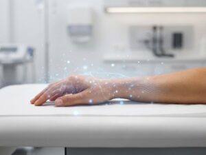 Hand met tintelende sensaties gevisualiseerd door lichtdeeltjes en zachte gloeiende effecten op medische achtergrond