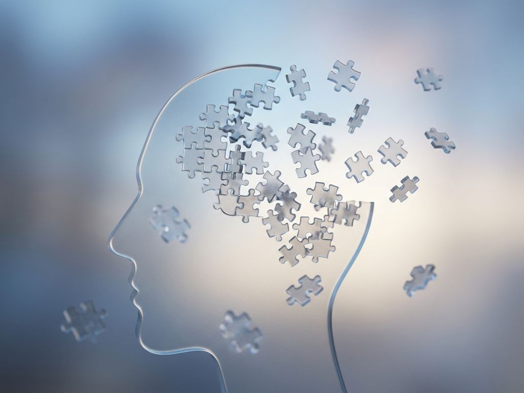 Menselijk silhouet met transparant hoofd waarin puzzelstukjes wegdrijven uit hersengebied, symboliseert concentratieproblemen